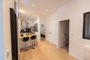 kuchnia z blatem i stołkami w pokoju w obiekcie KASA LOFT CENTRE 2 - WIFI et TV - Confortable et stationnement gratuit à proximité w mieście Saint-Étienne