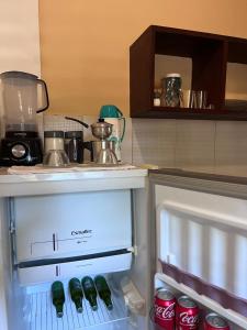 an open refrigerator with soda cans in it at Residencial Bem-te-vi in Jericoacoara