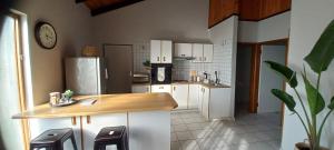 a kitchen with white cabinets and a counter with stools at Mucha Airbnb in Walvis Bay