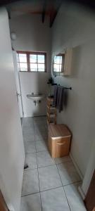 a bathroom with a tile floor with a sink and a window at Mucha Airbnb in Walvis Bay