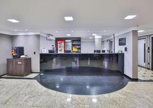 a lobby with a bar in the middle of a room at Vivendas Rio Claro by Atlantica in Rio Claro