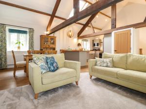a living room with two chairs and a table at Monkey Puzzle Cottage in Sedbergh
