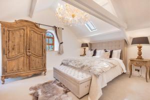 a bedroom with a large bed and a chandelier at Rose Walls in Stainton