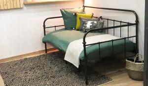 1 dormitorio con 1 cama con almohadas verdes y amarillas en atelier clermont ferrand historique, en Clermont-Ferrand