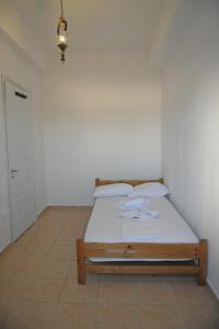 a small bedroom with a bed with white sheets at Armenistis appartments with a view in Armenistis