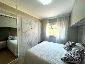 um quarto com uma cama grande e uma janela em Apartamento Villa Nova Master Collection em Passo Fundo