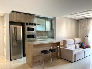 Apartamento Villa Nova Master Collection في باسو فوندو: مطبخ مع بار وأريكة في الغرفة