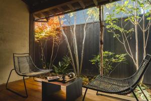 een patio met 2 stoelen en een tafel bij Maana Kyoto in Kyoto