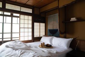 Una cama con una bandeja con dos velas. en Maana Kyoto, en Kioto