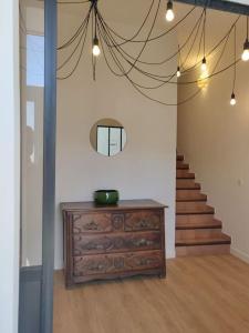 une chambre avec une commode et un escalier avec un miroir dans l'établissement La Maison de Colette - Coeur de village, à Cuxac-dʼAude