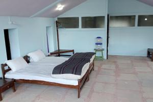 1 dormitorio con 1 cama en una habitación con ventanas en BAANZ CABIN - managed by The Silver Oak Place, en Pithorāgarh