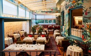 a restaurant with white tables and chairs and a room filled with tables at Sopwell House Hotel in Saint Albans
