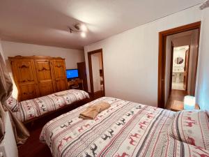 una camera con due letti e una tv di La Baita Limone Riserva Bianca Ski-in Ski-out Seggiovia Morel 2 a Limone Piemonte