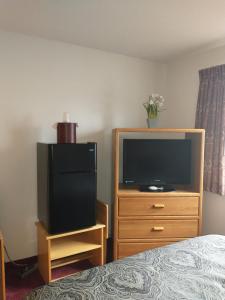 1 dormitorio con TV y vestidor con cama en Sauk River Inn & Suites, a Travelodge by Wyndham, en Sauk Centre