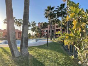 a resort with a swimming pool and palm trees at B2 Bajo con terraza de 32 m2 en Playa Granada in Motril