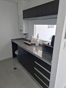cocina con armarios negros y encimera en Hermoso departamento cerca del parque y centro en Paraná