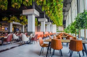 a restaurant with tables and chairs in a building at Best Western Plus Dubai Academic City in Dubai