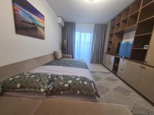 a bedroom with two beds and a flat screen tv at Ghencea Residence 158 L2.2 in Bucharest