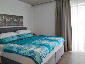 a bedroom with a bed with a blue and white comforter at Florianihof Sankt Marxen 