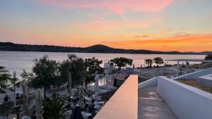een balkon met uitzicht op het water bij zonsondergang bij Apartman Belamaric in Šibenik