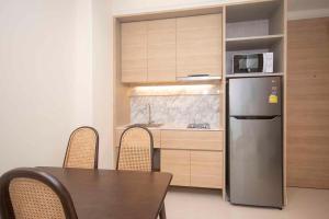 a kitchen with a table and a stainless steel refrigerator at Apartment in Aonang - great location with pool in Ao Nang Beach