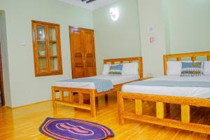a bedroom with two beds and a rug on the floor at Zanzibar Spice Nest Apartment in Stone Town