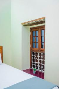 Zimmer mit Fenster und Weinregalen in der Unterkunft Zanzibar Spice Nest Apartment in Stone Town