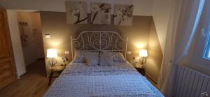 Minimal Chic House في بولونيا: غرفة نوم بسرير ولحاف ازرق ومصباحين