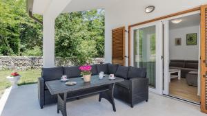a patio with wicker chairs and a table at Villa Ana by Villas Holiday in Labin