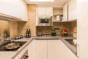 a kitchen with white cabinets and stainless steel appliances at Somerset Grandview Shenzhen in Shenzhen