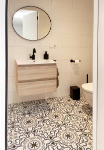 ein Bad mit einem Waschbecken und einem Spiegel in der Unterkunft Studio La Rose in Arnhem