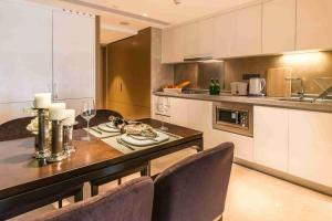 a kitchen with a dining table with chairs and a counter at Somerset Grandview Shenzhen in Shenzhen