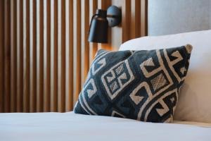 a pillow sitting on a bed next to a lamp at Colonna 24 Luxury Room in Portovenere near 5 Terre in Portovenere