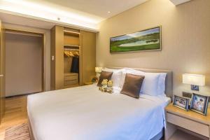 a bedroom with a large white bed with two teddy bears on it at Somerset Grandview Shenzhen in Shenzhen