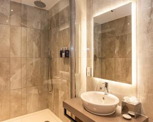 a bathroom with a sink and a shower at Hotel La Tour in Milton Keynes