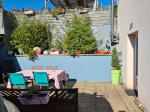 a patio with a table and chairs and plants at Le Cocon - Gite Spa et Sauna privatif en Centre Alsace in Saint-Maurice