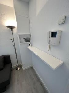 a room with a white wall with a counter and a lamp at Apartamento 1 dormitorio cerca hospitales in Zaragoza