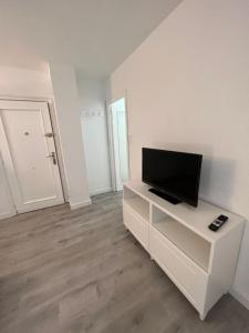 a living room with a flat screen tv on a white cabinet at Apartamento 1 dormitorio cerca hospitales in Zaragoza