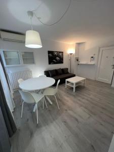 a living room with a table and chairs and a couch at Apartamento 1 dormitorio cerca hospitales in Zaragoza