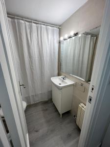 a white bathroom with a sink and a mirror at Apartamento 1 dormitorio cerca hospitales in Zaragoza