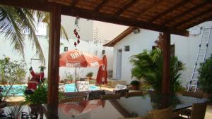 a patio with an umbrella and a swimming pool at Casa perto da praia com piscina, churrasqueira em SLZ in São Luís