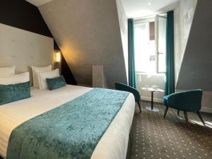 a hotel room with a bed and two chairs at Hotel de la Paix Tour Eiffel in Paris
