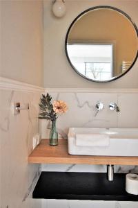 a bathroom with a sink and a mirror at Patio Riverfront Aparthotel in Gdańsk