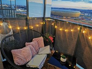 un balcone con sedia e luci su un edificio di Apartament przy Bursztynowym Stadionie a Danzica