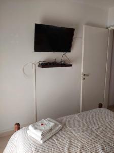 a bedroom with a bed with a flat screen tv on the wall at Habitación Privada en La Casa de Thor in Trelew