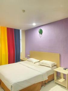 a bedroom with a bed with a colorful wall at Sri Indar Hotel in Bukit Mertajam