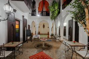 a room with tables and chairs in a building at Riad Alwane in Marrakech