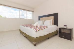 a bedroom with a large bed and a window at Casa Bella in Playa del Carmen