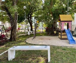 a park with a playground with a slide and a house at Casa Bella in Playa del Carmen
