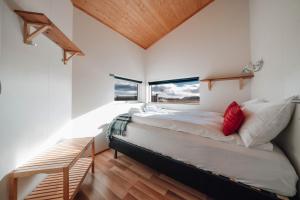 a bedroom with a large bed and two windows at Blue View Cabin 6A With private hot tub in Reykholt